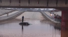 Firefighters in dinghy rescue man trapped in flood under bridge