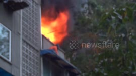 Firemen extinguish flames to save man trapped on awning