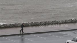 Boy struggles to walk against wind in Ireland