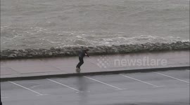 Boy fights against strong Ireland winds while walking