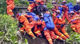 Firefighters form 'human bridge' on cliff to transfer elderly people out of village after earthquake in China