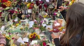 People lay flowers outside Buckingham Palace for the Queen