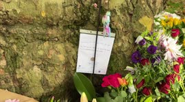 Queens floral tribute green park- child leaves lovely message for queen with a 20p coin