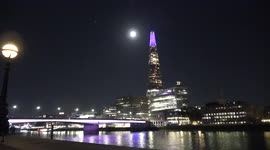 Amazing full harvest moon rises over the Shard in London lit up in purple to pay tribute to Queen
