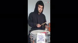 Cat adorably goes into owner's hoody while he plays drums