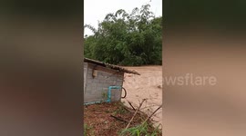 Outdoor toilet plunges into swollen river as floods erode foundations
