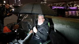 A highly well prepared man sits in the queue to see the Queen at Westminster Hall. He came prepared with drinks, food and an array of batteries