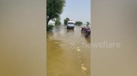 Pakistan rescue teams ride rubber dinghy to cross deluge in flooded village