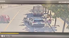 Motorist risks life to stop three-wheeler carrying child darting across road in China