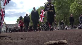 Queen's cortege passes along the Mall followed by royal family, led by King Charles