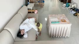 Wholesome moment toddler covers pregnant mother with blanket as she falls asleep on sofa