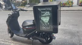 London moped equipped with screen showcasing images that commemorate Queen Elizabeth