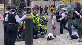 London Ambulance motorbike paramedic tries to right bike after mishap after collision with car