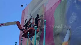 Brazilian muralist Eduardo Kobra prepares a mural on the facade of the UN in New York City