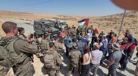 Palestinian protesters argue with Israeli soldiers at demonstration against settlements