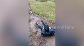 Tired hiker 'gives up,' amuses fellow climbers as he slips and slide down muddy trail
