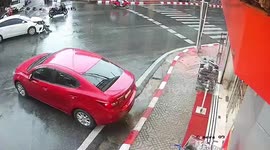 Car narrowly avoids smashing into shop after colliding with another sedan at junction