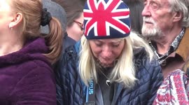 People wipe their tears and close their eyes in mourning during Queen's funeral