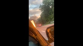 A semi truck on the highway catches into flames