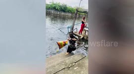 Clumsy tourist falls into canal while feeding fish