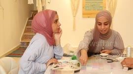 Palestinian women use silver, gemstones, copper, and strings during a class to make miniature handicrafts inside the