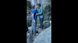 Guy proposes to girlfriend in front of waterfall on her favorite trail