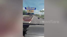Loose truck wheel wobbles down road in Thailand