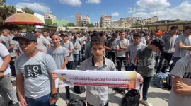 Palestinian students hold placards during a protest against a new Israeli-imposed curriculum in Jerusalem, in Gaza city