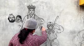 Artist draws characters from Chinese novels on wall with flaming wooden sticks