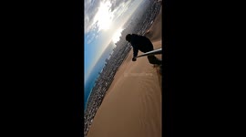 Beautiful scene as daredevil surfs down huge sand dune with incredible view of Iquique city in Chile