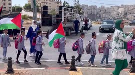 Palestinian students wave national flags during a rally in solidarity with Palestinian president Mahmoud Abbas before his speech on the 77th session of the UN General Assembly