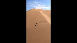 Athlete Cristian Calcagno performs descent in giant dunes, capturing the images by a drone