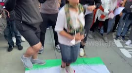 Mahsa Amini protesters stomp the on an Islamic Republic of Iran flag in Trafalgar Square