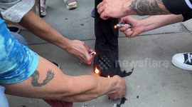 Protesters attempt to burn a hijab and Iranian flag at Mahsa Amini rally in London's Trafalgar Square