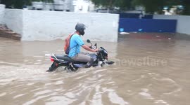 Heavy rains flood streets in Delhi, India, causing traffic jams and travel chaos