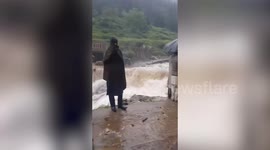 Driver's lucky escape after car swept away by floodwaters while crossing water-filled road