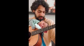 Belgian musician plays guitar with adorable newborn balancing on instrument