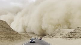 Cars flee giant wall of sand in northwest China in July