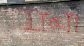Protesters spray paint “Iran Revolution” outside the Iranian Embassy in London