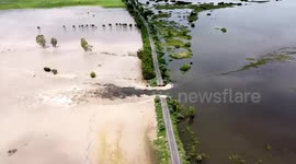 Flood breaks through reservoir wall spilling over highway in Thailand