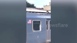 Daredevil 'subway surfer' hangs between moving train carriages in New York