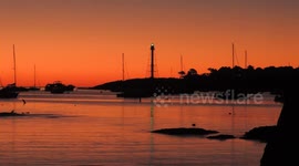 Long red sky clip of Marblehead Light Tower and its green light reflecting