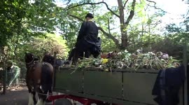 Horses pull a cart with floral tributes to the Queen into compost lodge in Kensington Gardens