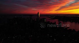 Beautiful and ominous red sky looms over New York City skyline in aerial video