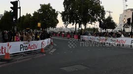 The last runners struggle to get round the last mile of the London Marathon including a firefighter in full firefighter gear