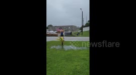 Man braces in Hurricane Ian’s strong winds with US flag in hand