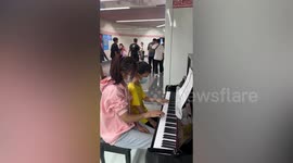 Boy and girl show off piano skills with subway station duet in China