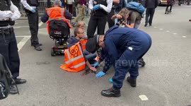 Police officers arrest Just Stop Oil climate activists who glued themselves to the roads in Parliament Square