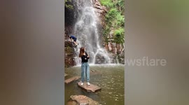 Funny moment woman's photo at scenic waterfall is ruined by accidental photobomb