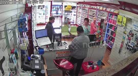 Bizarre moment female thief distracts shopkeeper by dancing while pal stuffs goods down her top